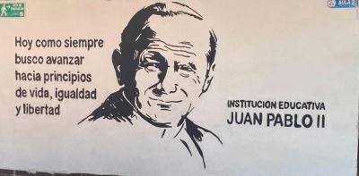 Imagen del papa Juan Pablo II y lema institucional en una de las paredes de la sede educativa.